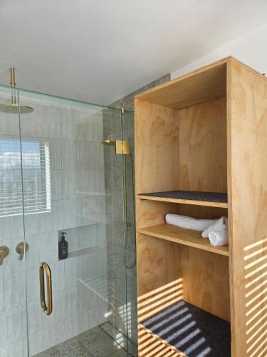 a bathroom with a shower and a glass shower stall at The Landing - Picton in Picton