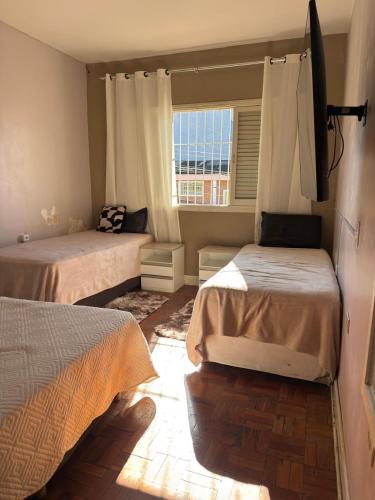 a bedroom with two beds and a window at Sobrado versátil in Santo André