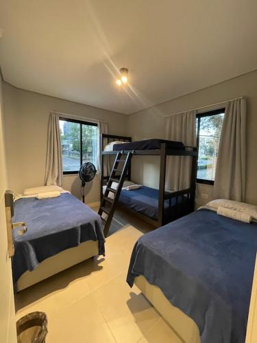 a bedroom with two beds and a bunk bed at Social Hostel Café e Bar in Curitiba