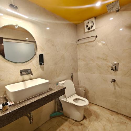 a bathroom with a sink and a toilet and a mirror at Tapovan Namaste in Rishīkesh