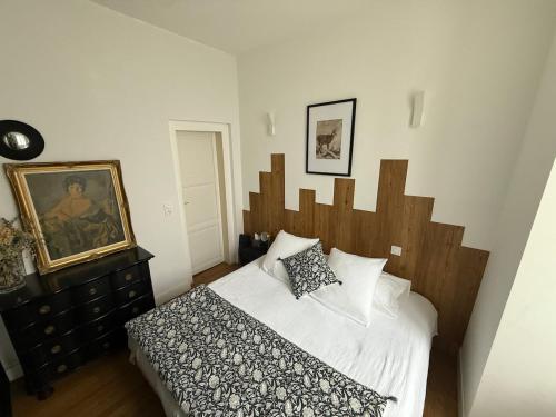 a bedroom with a bed with a wooden headboard at App T2 avec piscine chauffée in Luchon