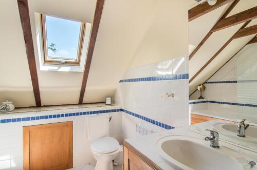 a bathroom with a sink and a toilet and a window at La Sérénité in Najac