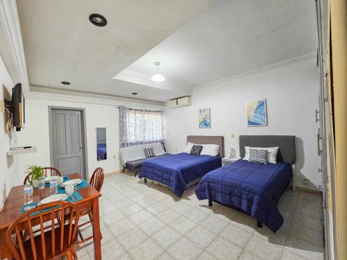 a living room with two beds and a table and a couch at Casa San Luis in Tuxtla Gutiérrez