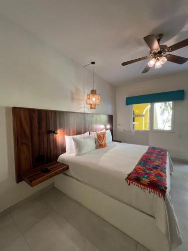 a bedroom with a bed and a ceiling fan at El Encanto Inn & Suites in San José del Cabo