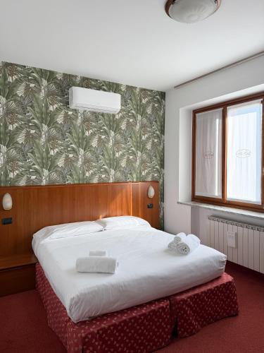 a bedroom with a bed with two towels on it at Fell Hotel in Susa
