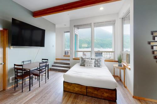 a bedroom with a bed and a table with chairs at Lake Sutherland Retreat in Port Angeles