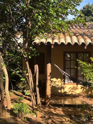 a house with a shingled roof and a porch at Espaço Amarelo in Pirenópolis