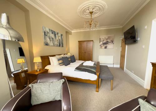 a bedroom with a bed and a couch and a chair at St Michaels Reach Guest House in Marazion