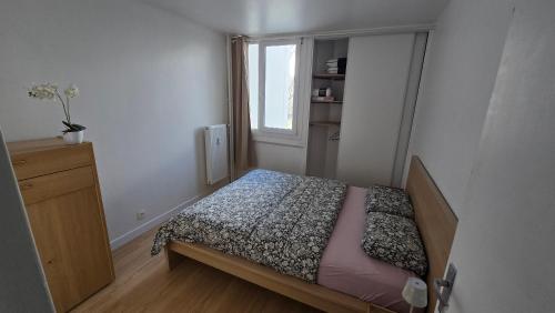 a small bedroom with a bed and a window at Appartement proche Lille in Mons-en-Baroeul