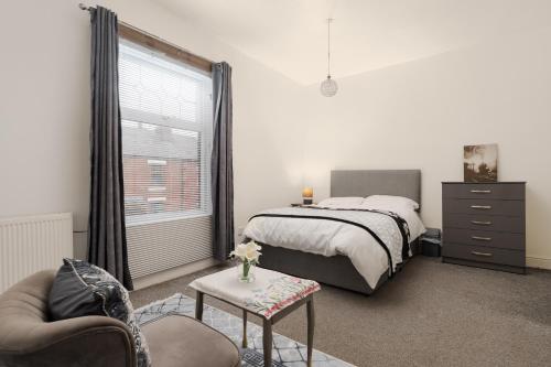a bedroom with a bed and a chair and a window at Modern 3-Bedroom Home in-Steps from Crown Point in Denton