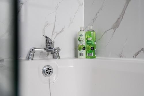 a bathroom sink with two bottles of soap on it at Modern 3-Bedroom Home in-Steps from Crown Point in Denton