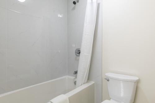 a white bathroom with a toilet and a shower at Super 8 by Wyndham Golden in Golden