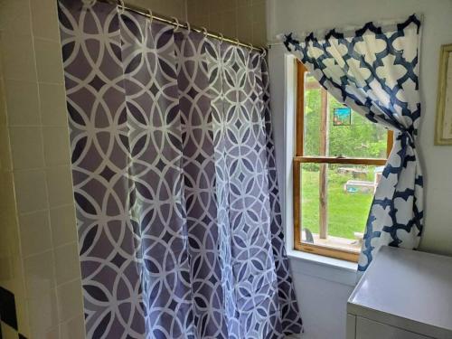 a shower curtain in a bathroom with a window at Vermont Escape, Too in Warren