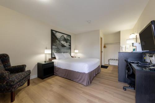 a hotel room with a bed and a chair at Super 8 by Wyndham Golden in Golden