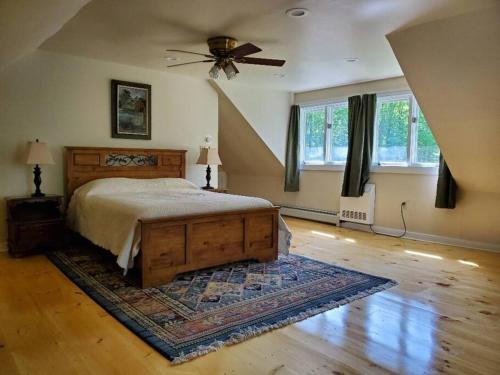 a bedroom with a bed and a ceiling fan at Vermont Escape, Too in Warren