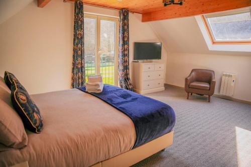 a bedroom with a bed and a window and a chair at Maple Lodge in Knighton