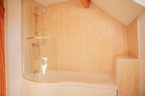 a bath tub in a bathroom with a shower at Maple Lodge in Knighton