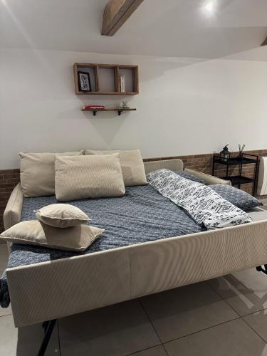 a bed with two pillows on it in a room at A la ferme - Colline Beaumont in Colline-Beaumont