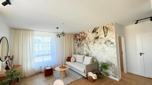 a living room with a couch and a painting on the wall at Apartament Moje Moderato II w Starogardzie Gdańskim in Starogard Gdański