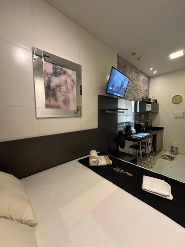 a room with a bed and a desk with a computer at Flat jk 03 térreo in Juazeiro do Norte