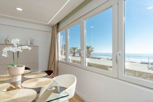 a dining room with a glass table and a view of the beach at The View II Costa Caparica ( private parking ) in Costa da Caparica
