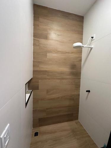 a bathroom with a wooden wall and a door at Flat jk 03 térreo in Juazeiro do Norte
