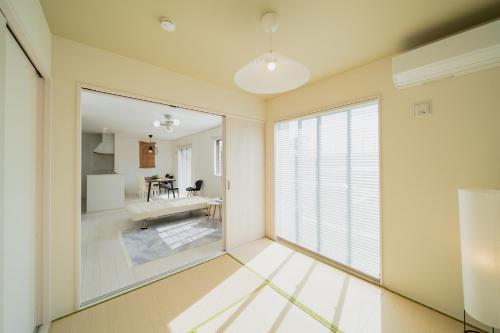 a room with a large window and a dining room at Guesthouse tontonmie in Gimbaru