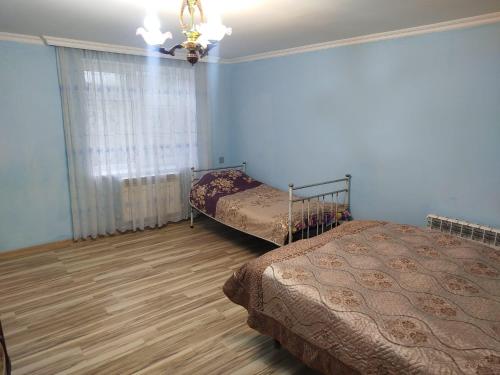 a bedroom with two beds and a window at Rest House in Quba