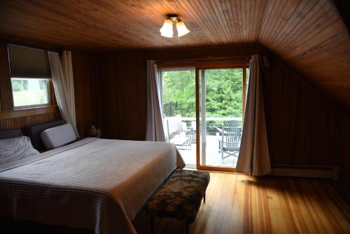a bedroom with a bed and a large window at Belknap Point Inn in Gilford
