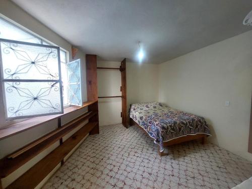 a small bedroom with a bed and a window at Casa Verano in Guanajuato