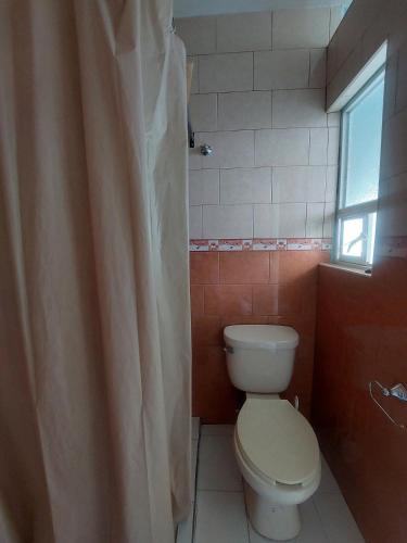 a bathroom with a toilet and a shower curtain at Casa Verano in Guanajuato