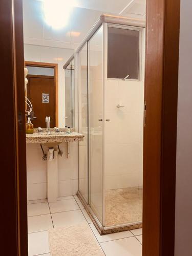 a bathroom with a glass shower and a sink at Flat Lagoa Santa in Lagoa Santa