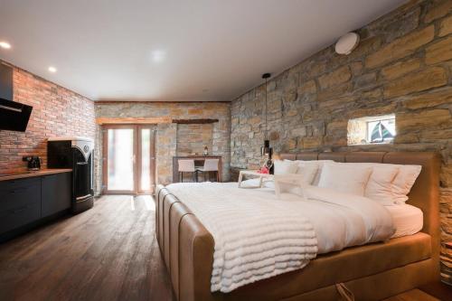 a bedroom with a large bed and a stone wall at Istrian Perfect Life in Šmarje