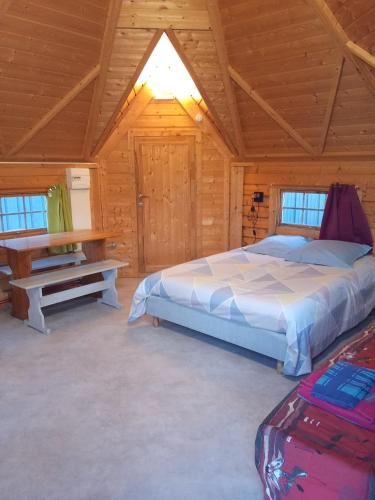a bedroom with a bed and a table in a cabin at kota en Normandie in Couvains