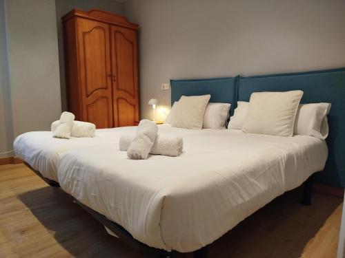 a large white bed with white pillows on it at R2R - Apartamento cerca del mar - 14A12 in Lastres