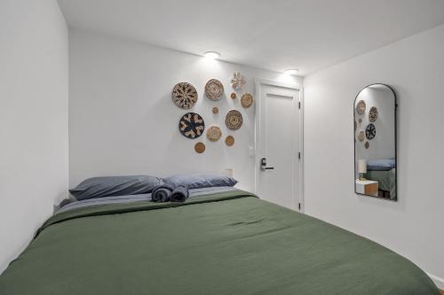 a bedroom with a green bed and plates on the wall at Times Square Heart - The Global Nook - Cozy Private Room in New York