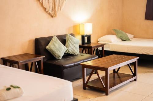 a living room with a couch and a bed and tables at We playa Hotel - Adults Only in Playa del Carmen