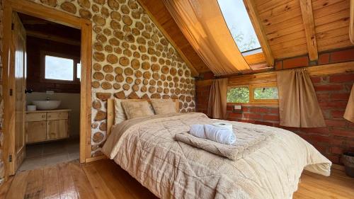 a bedroom with a bed in a stone wall at El Tiklan Glamping in Chucchilán