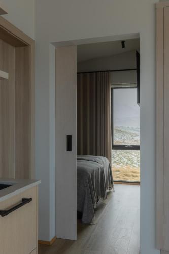 una camera da letto con un letto e vista sull'oceano di Peninsula Suites a Hellnar