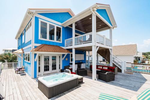 a blue house with a hot tub on a deck at Paws and Relax! in Carolina Beach