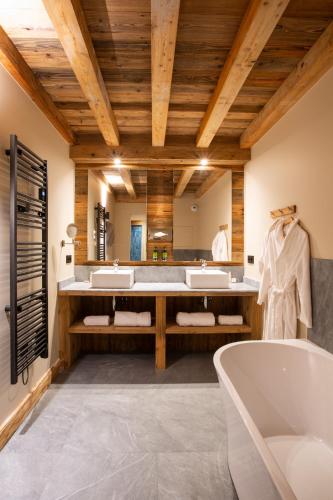 a bathroom with three sinks and a tub at Hotel & Spa Merilys in Méribel