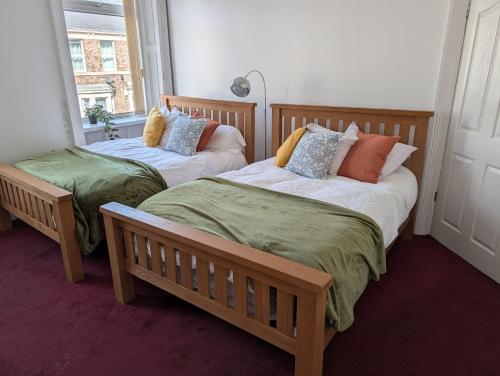 two beds sitting in a room with a window at Affleck Street in Gateshead