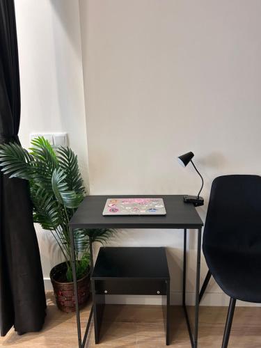 a black desk with a lamp and a plant at Apartamentos Bajo La Viga con Piscina in Salamanca