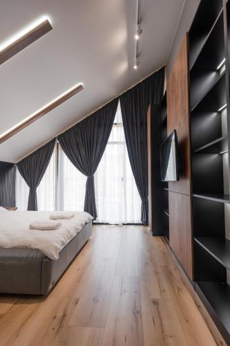 a bedroom with a large bed and large windows at GoldHill villas 9 in Yaremche