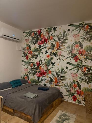 a bedroom with a wall with a floral wallpaper at Studio Ça Mconvient in Cayenne
