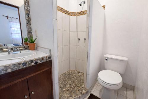 a bathroom with a toilet and a sink and a shower at Casa Alma in Brisas de Zicatela