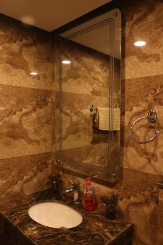 a bathroom with a sink and a mirror at Designer Den two Bed apartment opposite to giga mall in Islamabad