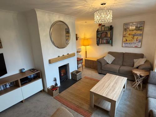 a living room with a couch and a table at Lovely cottage in Snowdonia, private hot tub, by mountains & award winning beach in Fairbourne
