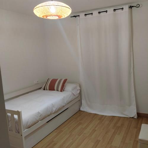 a white room with a bed and a chandelier at Las heras apartamento in Medrano
