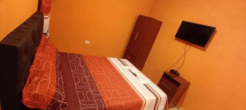 a bedroom with a bed and a tv on the wall at Apart Fiambala alojamiento in Fiambalá